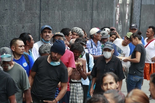 Personas en situación de calle esperan recibir una ración de comida a las afueras del Teatro Blanquita. Foto Alfredo Domínguez

