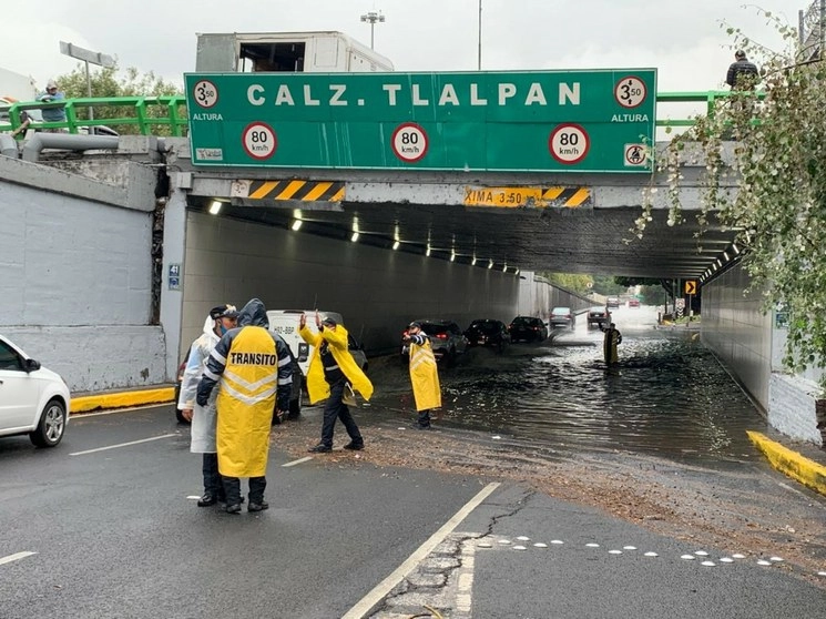 Elementos de la SSC agilizan el tránsito de vehículos en Viaducto, a la altura de Tlalpan, tras la lluvia que cayó en la Ciudad de México este lunes. Foto Alfredo Domínguez