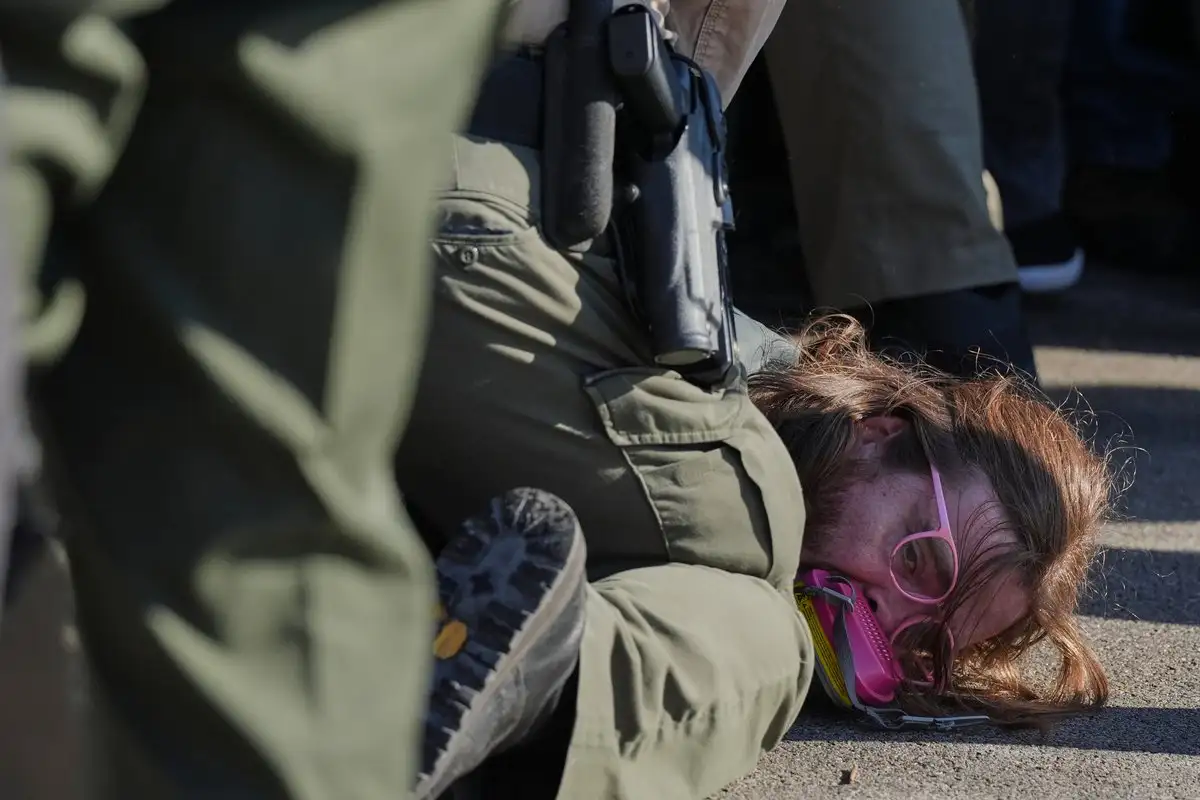  Un agente detiene a un manifestante frente a un centro de procesamiento del ICE en un suburbio de Illinois.