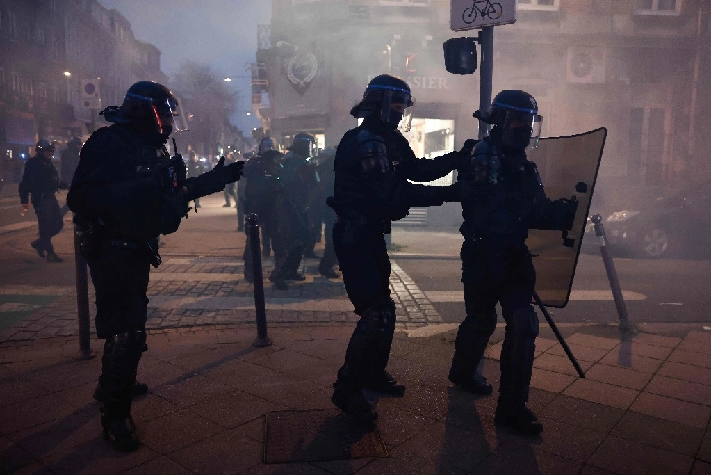 Policías franceses antidisturbios intentan contener una manifestación, luego de que el gobierno aprobara la polémica reforma de pensiones. Foto Afp