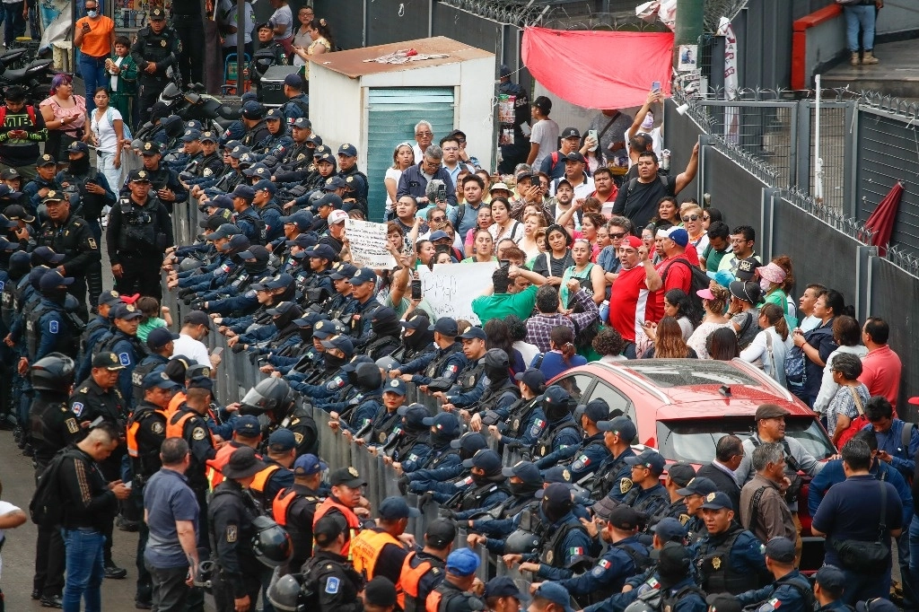 Trabajadores de la SEP son encapsulados por elementos de la SSCCDMX durante una protesta afuera de la estación del Metro Terminal Aérea, sobre Circuito Interior, en la capital del país. Foto Víctor Camacho
