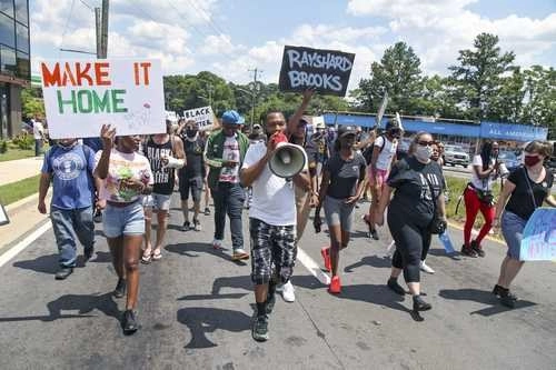 Manifestantes se reúnen cerca de un restaurante Wendy's, en Atlanta, donde fue muerto un joven afroestadunidense.Foto Ap