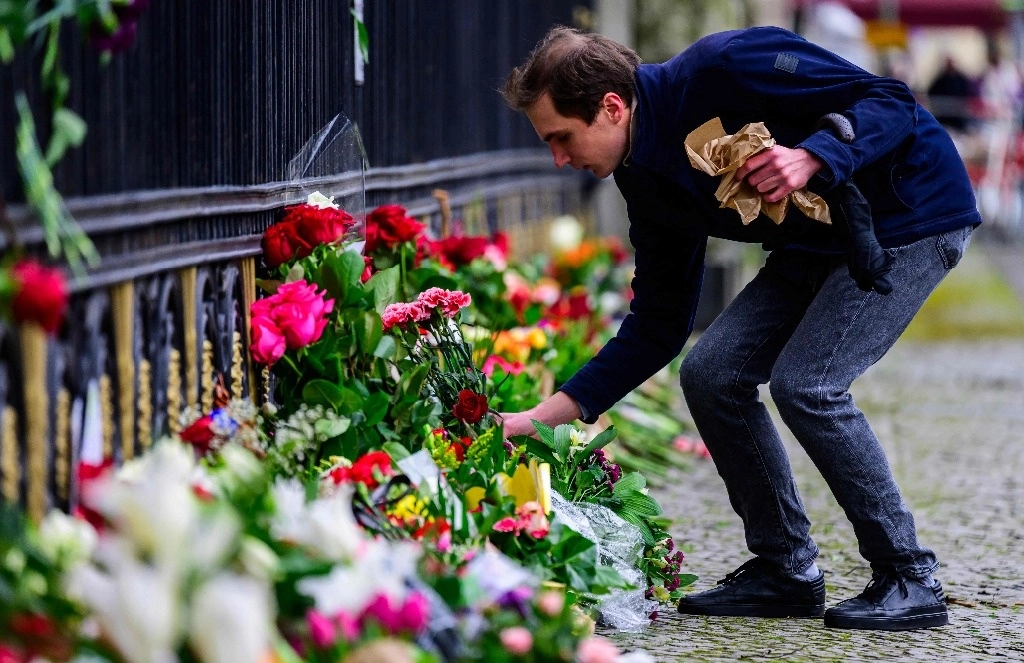 Un hombre deja flores este domingo en un memorial improvisado para las víctimas del ataque en Krasnogorsk, en la embajada rusa en Berlín. Foto Afp