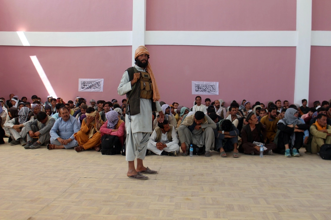 Miembros de las fuerzas de seguridad de Afganistán que se rindieron en la ciudad de Ghazni son vigilados por un combatiente talibán, el 13 de agosto de 2021. Foto Ap