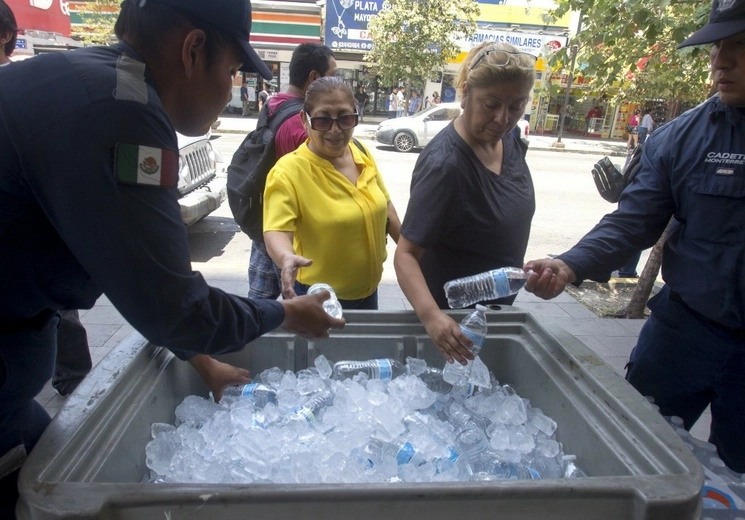 Las altas temperaturas en Nuevo León superan los 40 grados, Protección Civil alerta que los próximos días podrían alcanzar los 47 grados. Policía municipal ofrece agua a peatones en el centro de la ciudad. Foto Cuartoscuro