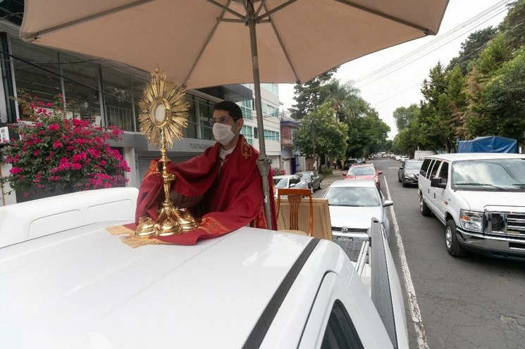 Un padre católico oficia una misa desde una camioneta en la calle Heriberto Frías, en la colonia Del Valle, Ciudad de México. Foto Pablo Ramos / Archivo