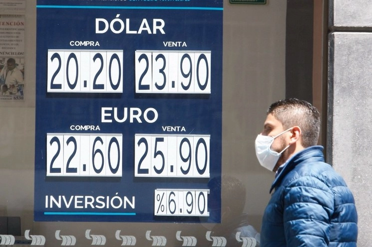 Persona con cubrebocas camina frente a una institución bancaria en CDMX este 17 de marzo de 2020. Foto Roberto García
