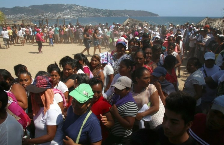 Vendedores de playas, desesperados por la falta de apoyos ante la contingencia sanitaria, tratan de conseguir una despensa que el ayuntamiento de Acapulco repartió el pasado 9 de abril. Foto Cuartoscuro