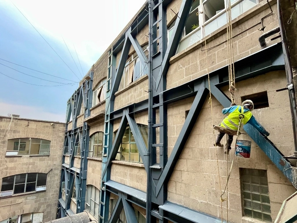 Un trabajador pinta la estructura metálica del edificio de Gobierno de la Ciudad de México. Foto Roberto García Ortiz / Archivo