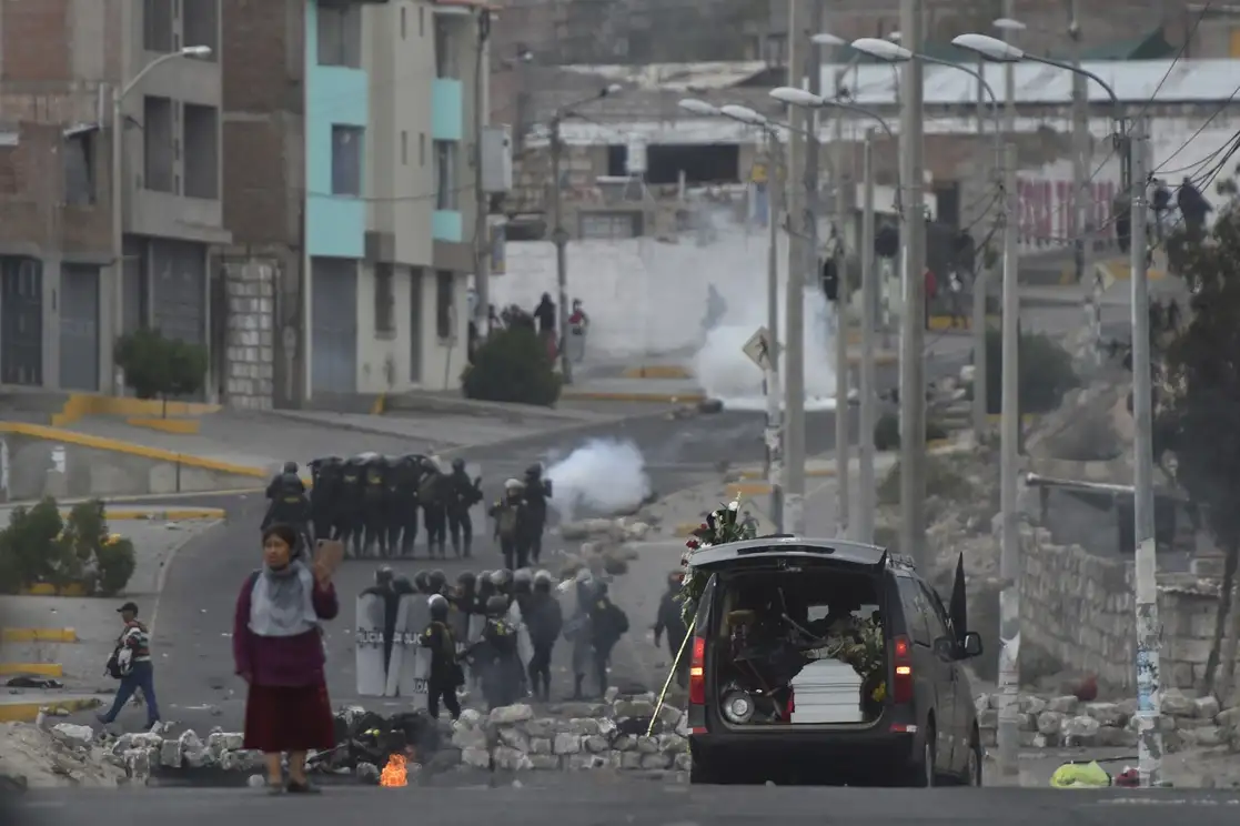 La carrosa fúnebre con los restos de Jhan Carlos Condori Arcana pasa durante los enfrentamientos entre las fuerzas de seguridad y manifestantes antigubernamentales, frente al aeropuerto Alfredo Rodríguez Ballón, en Arequipa. Foto:Ap