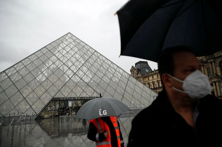 Un turista con una máscara se aleja del museo del Louvre, en París, mientras la gerencia se reunía con el personal preocupado por posible propagación del Covid-19. Foto AP