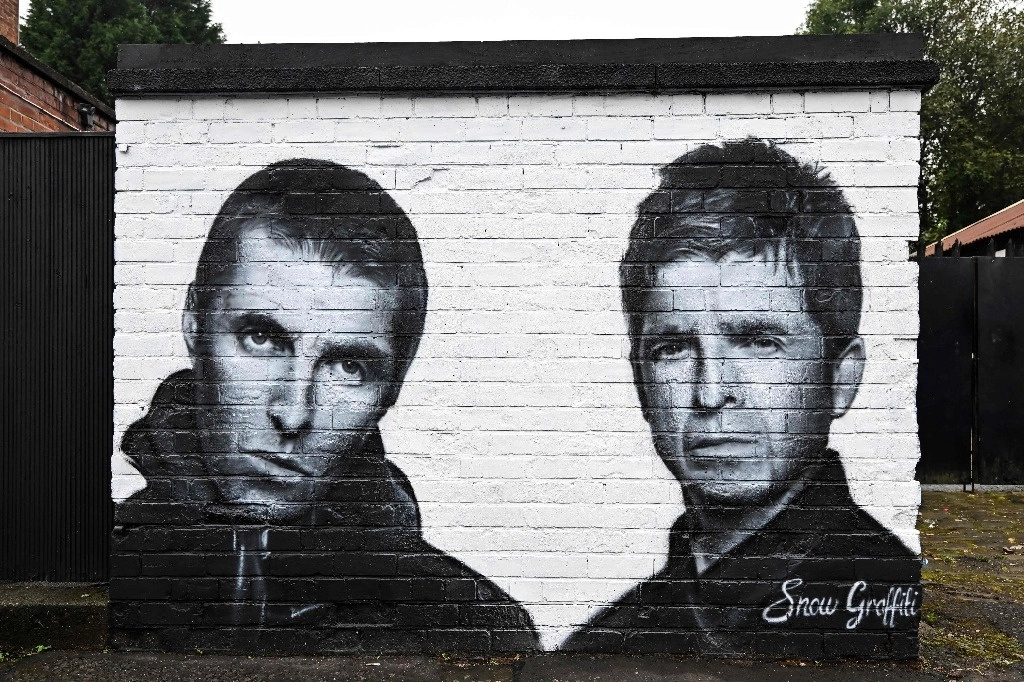 Un mural creado por el artista Scott Wilcock, también conocido como Snow Graffiti, representa a Liam Gallagher (izq.) y Noel Gallagher (der.), miembros de la banda de rock británica Oasis, fue trazado afuera del pub Whitefield, cerca de Heaton Park, en Manchester, al norte de Inglaterra, el 2 de septiembre de 2024. Foto Afp