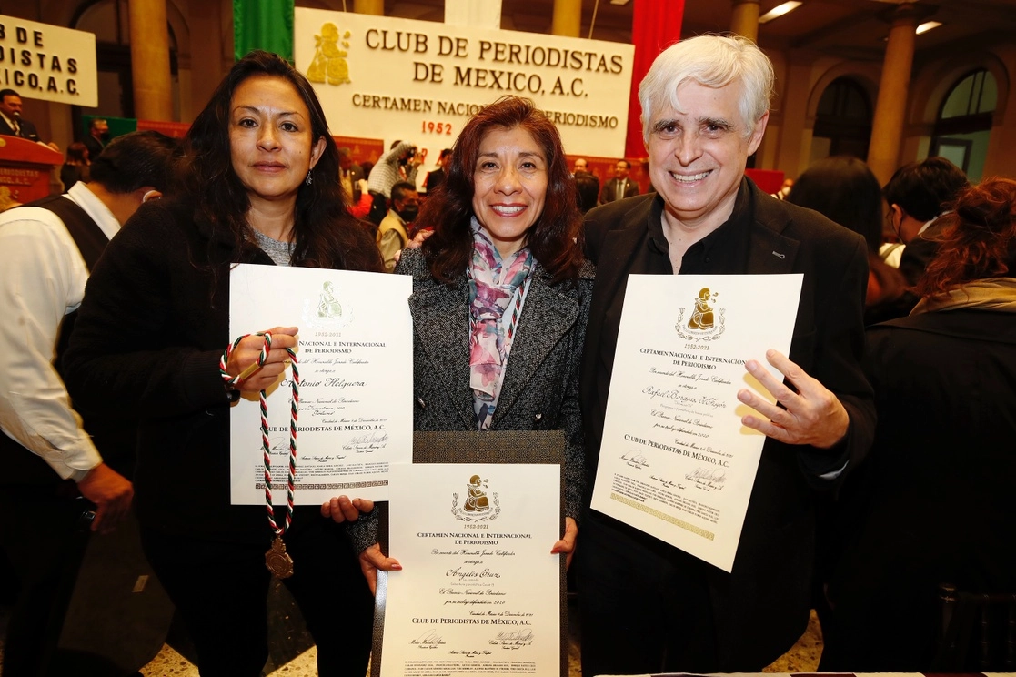 Alma Muñoz (izq.), reportera y viuda del caricaturista Antonio Helguera –en homenaje póstumo–, y Ángeles Cruz, quien ha cubierto la pandemia de Covid-19, son acompañadas por el monero Rafael Barajas ‘El Fisgón’, durante la entrega del Premio Nacional de Periodismo, ayer. Foto Cristina Rodríguez