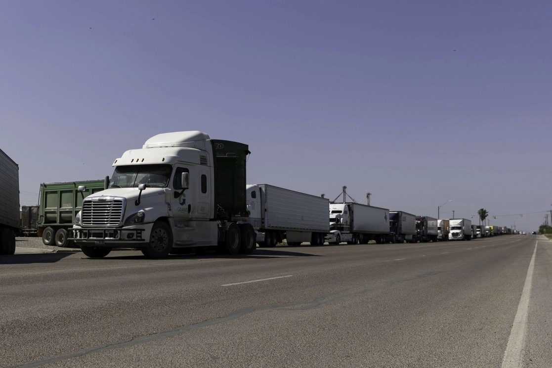Cientos de camiones comerciales esperan en fila para cruzar el puente Progreso que une a Texas con Tamaulipas. Foto Afp / Archivo