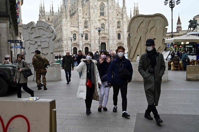 Turistas con tapabocas frente al Duomo, en el centro de Milán, Italia. Foto Afp