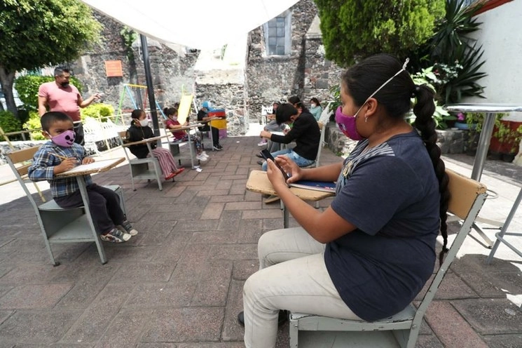 Niños asisten al atrio de la Capilla de la Santa Crucita, donde pueden acceder a Internet gratis y tomar sus clases en línea, en la alcaldía Xochimilco, CDMX. Foto Luis Castillo / Archivo