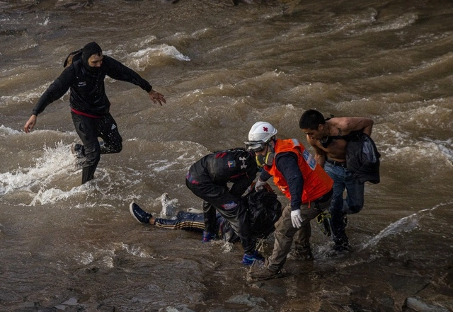 Paramédicos y manifestantes ayudan a un joven que fue arrojado por un policía al lecho de piedras y cemento del río Mapocho. Foto Ap