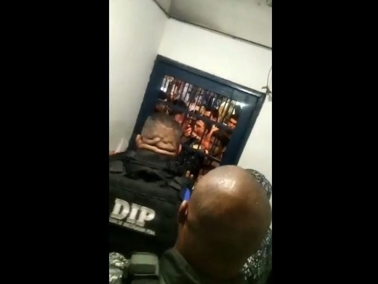 En videos difundidos en redes sociales se observa a uno de los policías presionado contra las rejas del calabozo por varios de los presos. Captura del video difundido en la cuenta de Twitter @oveprisiones