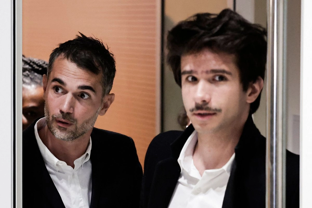 El autor francés Aurélien Poirson-Atlan, también conocido como Zoe Sagan, y el abogado franco-español Juan Branco salen durante un receso en el juicio contra diez personas acusadas de ciberacoso sexista contra la esposa del presidente francés, en París, el 28 de octubre de 2025. 