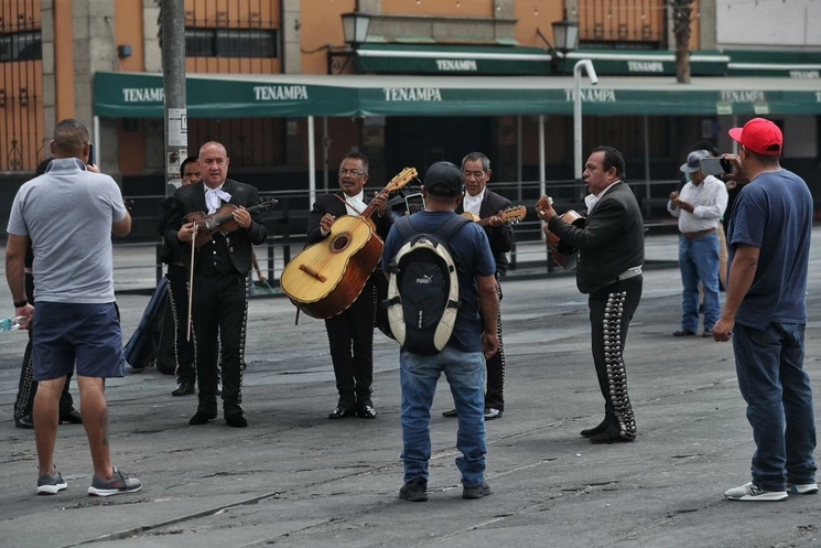 Mariachis cantan "Las mañanitas" mientras los clientes que los contrataron los graban para sus madres, en la explanada de la Plaza de Garibaldi, en la Ciudad de México, el 10 de mayo de 2023. Foto Marco Peláez


