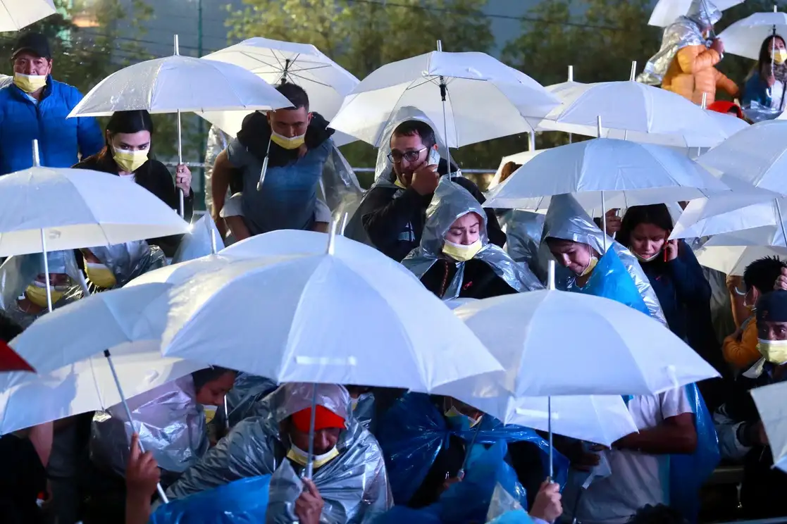 Personas protegiéndose de la lluvia en un evento de la CDMX, en imagen de archivo. Foto Luis Castillo