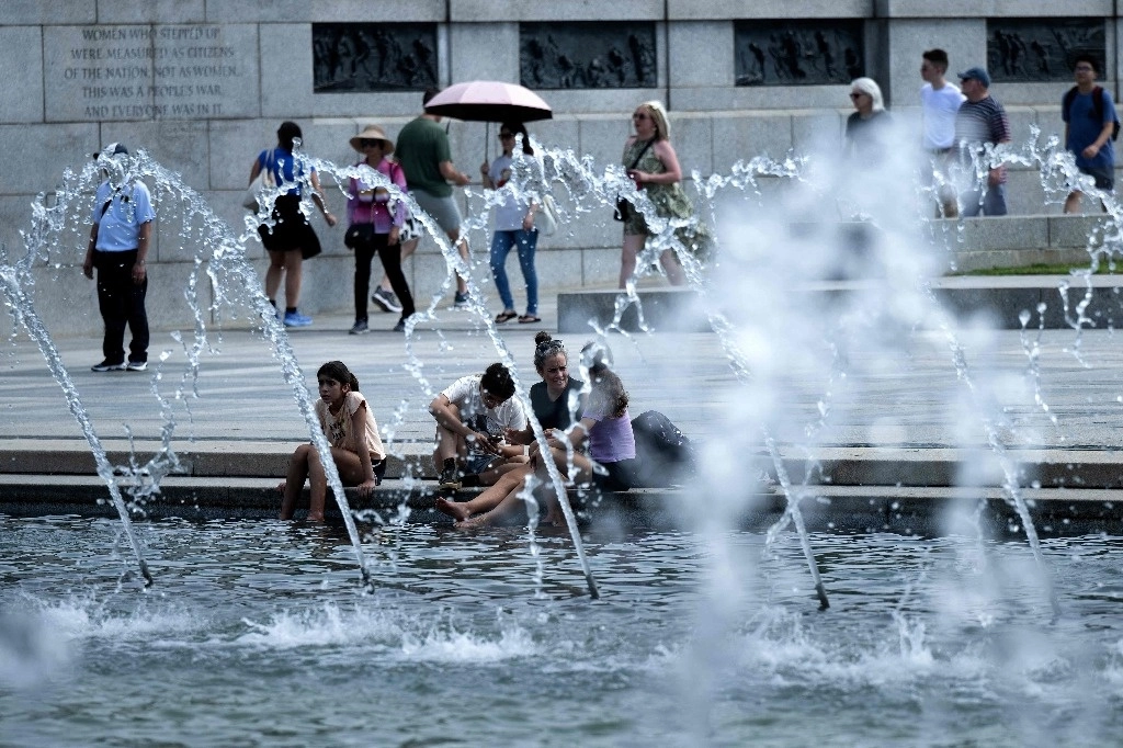 Personas se refrescan en una fuente de Washington, DC, ante las altas temperaturas que se registran en el este de EU. Foto aFP