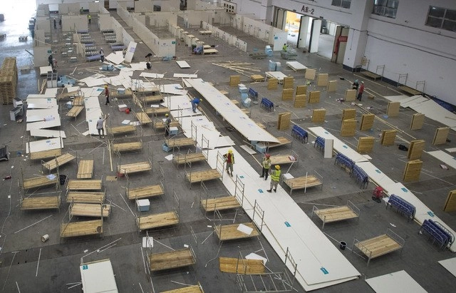 Trabajadores retiran las instalaciones del hospital improvisado "Wuhan Livingroom", en China. El lugar volverá a su uso original como centro de exposiciones. Foto Xinhua
