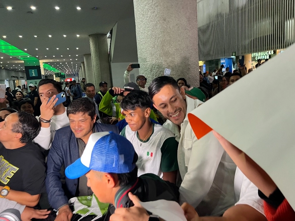 La judoca mexicana (centro) desató el caos en el aeropuerto capitalino, pues gran cantidad de gente deseaba tomarse una fotografía con la histórica deportista. Foto Alberto Aceves
