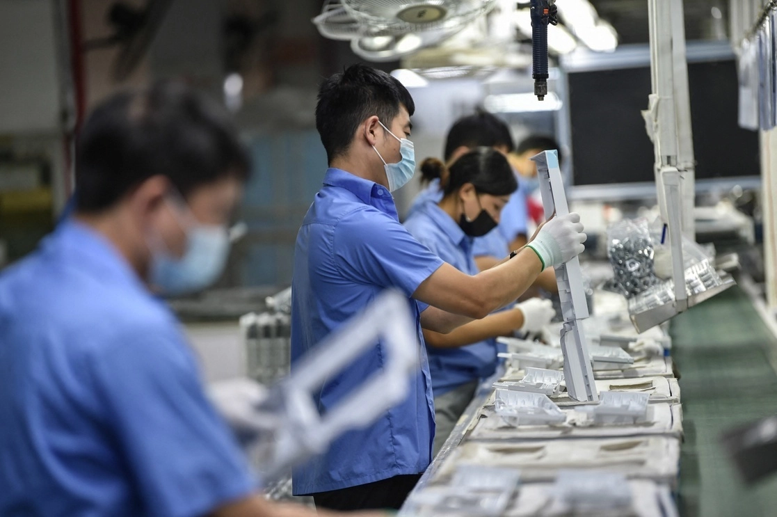 Empleados de una fábrica en imagen de archivo. Foto Afp
