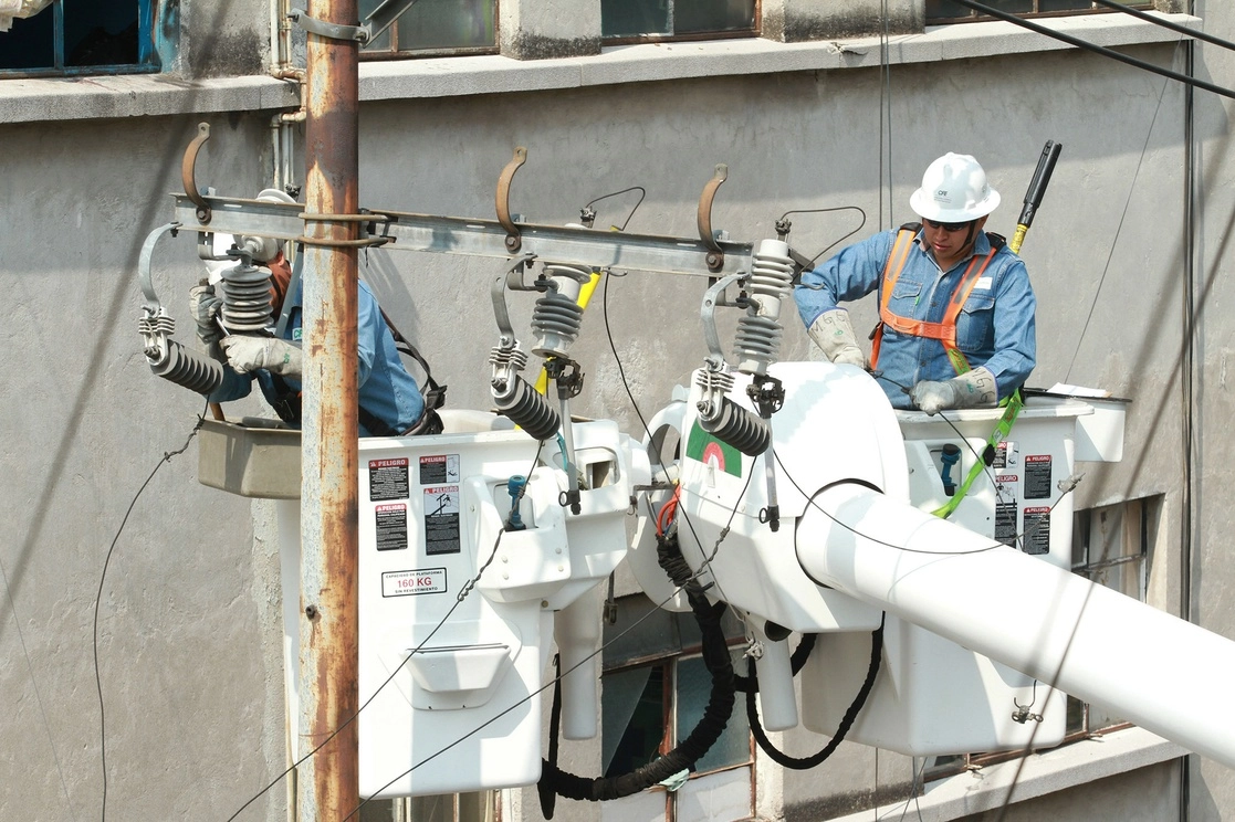 Trabajadores de la CFE reparan una línea de alta tensión en la Ciudad de México. Foto María Luisa Severiano 
