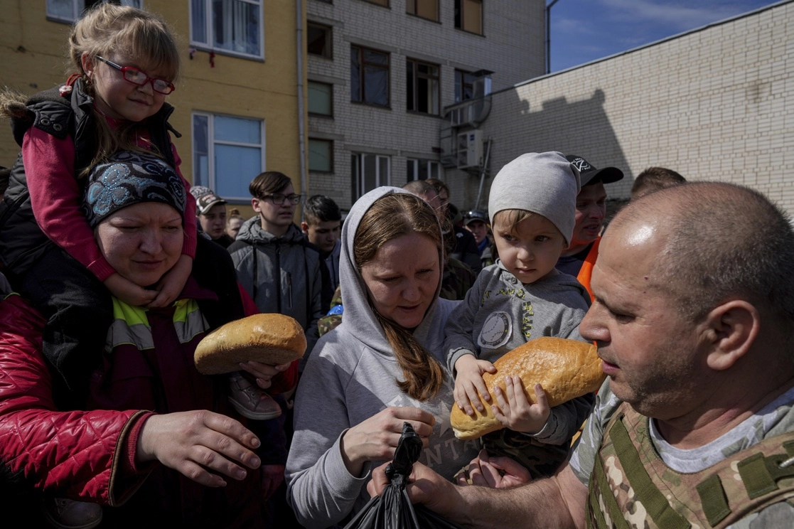 Familia ucrania recibe ayuda humanitaria en el patio de una escuela en Chernígov, Ucrania, el pasado 7 de abril. Foto Ap
