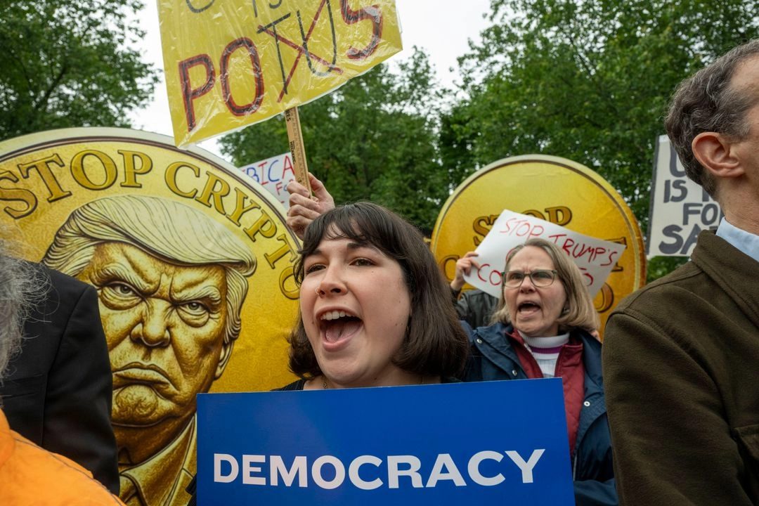 Protesta frente al Campo Nacional de Golf Trump, en Virginia, por los beneficios personales del mandatario al promover su criptomoneda.