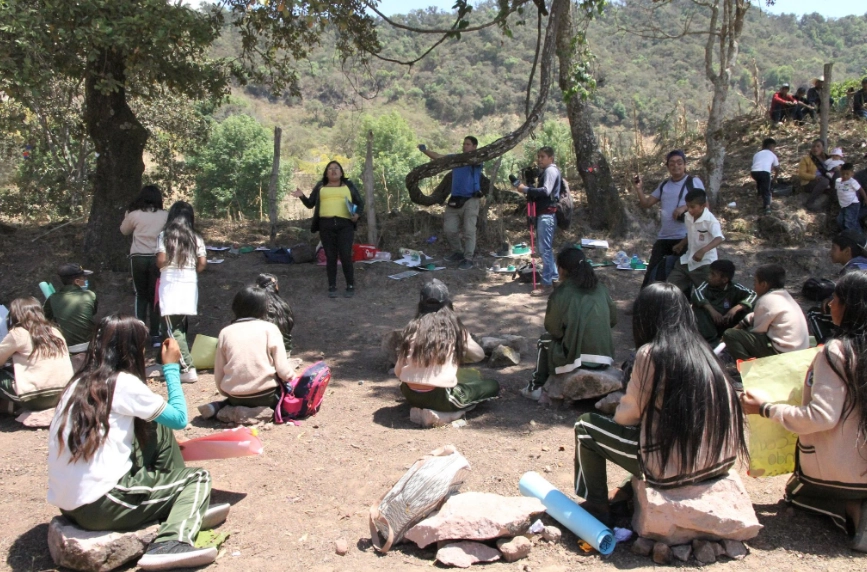 Los alumnos de la telesecundaria del poblado nahua de Ayahualtempa, en la Montaña baja de Guerrero, toman clases al aire libre, bajo un árbol; utilizan piedras como sillas y huacales como pupitres. Foto Sergio Ocampo