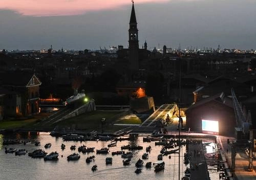 Gente mira desde las góndolas la película The Prestige, de Christopher Nolan, en la apertura de Barch-in, primer autocine en Italia, el cual se localiza en la antigua base naval Arsenal. Foto Afp