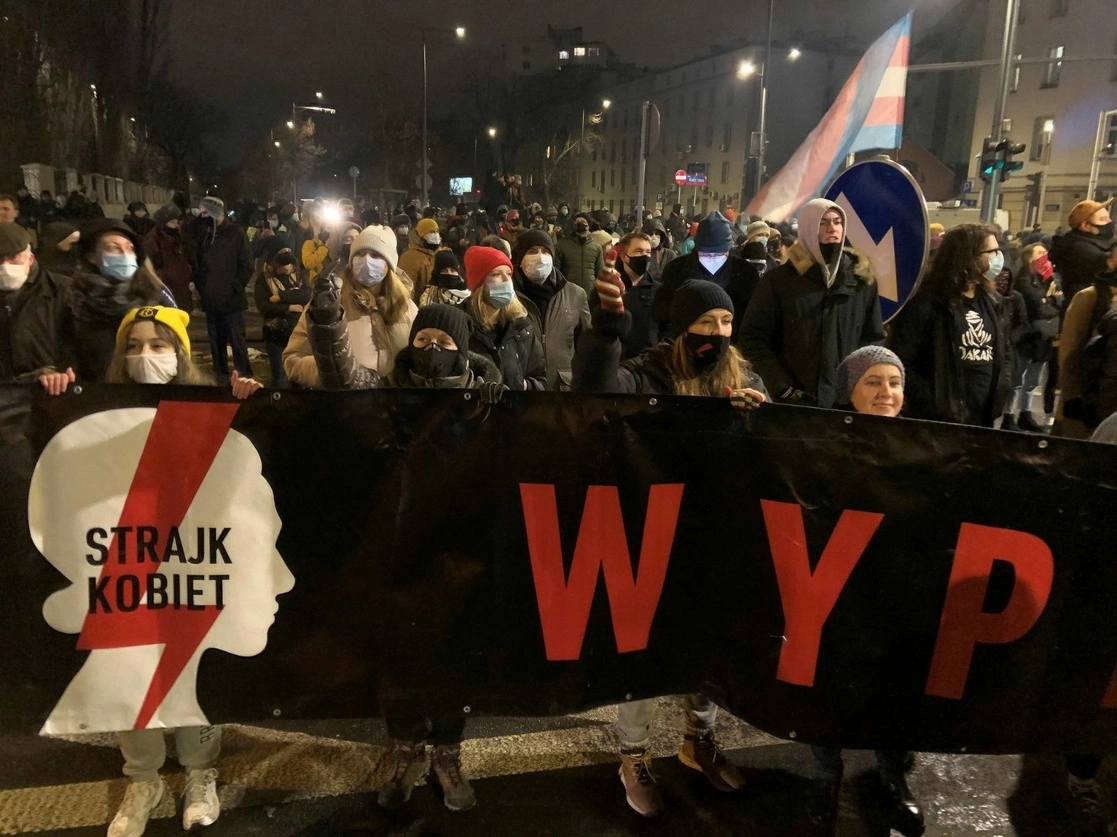 Un grupo de gente marcha cerca de la sede del partido gobernante Ley y Justicia en Varsovia, para protestar después de que el tribunal superior del país confirmó su fallo altamente divisivo que endurecerá aún más la estricta ley antiaborto de la nación predominantemente católica, en la capital polaca, el 27 de enero de 2021. Foto Ap