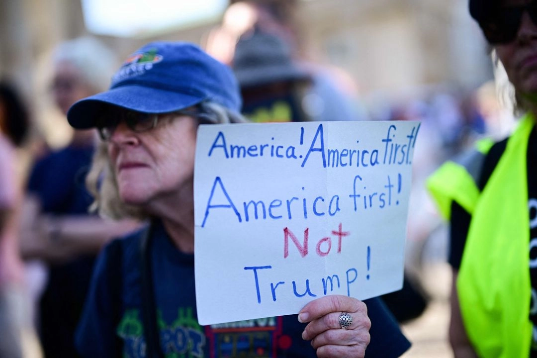 Un manifestante sostiene una pancarta con la leyenda "Estados Unidos primero, no Trump" durante la protesta del 4 de julio de 2025, en Berlín, conmemorando el Día de la Independencia de Estados Unidos.