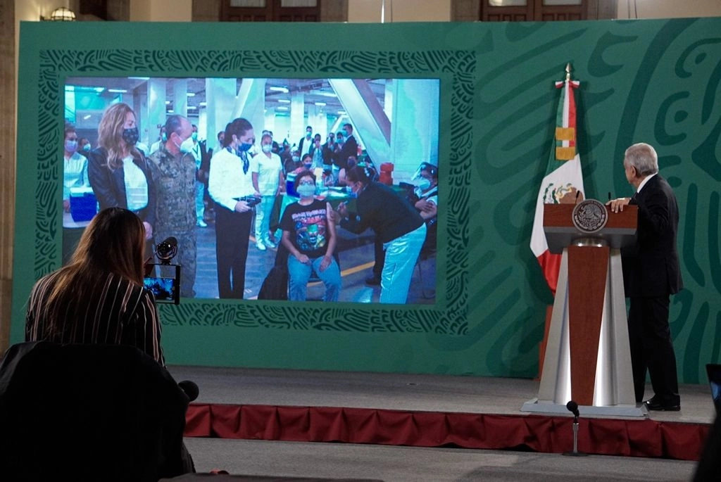 El presidente López Obrador observa el inicio de la aplicación de la vacuna anti Covid-19 a docentes en la CDMX, que atestiguó la jefa de Gobierno, Claudia Sheinbaum, durante la conferencia de prensa matutina en Palacio Nacional. Foto Pablo Ramos