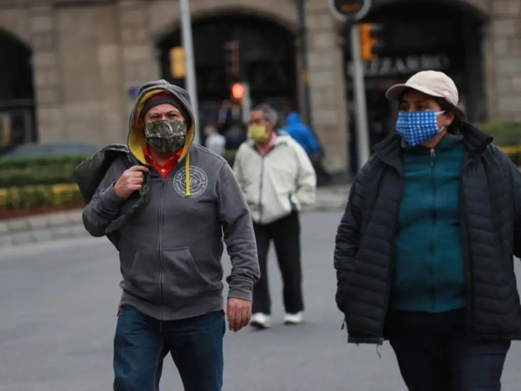 Ciudadanos caminan abrigados por las calles del Centro Histórico, debido a las bajas temperaturas registradas hoy en la capital. Foto María Luisa Severiano