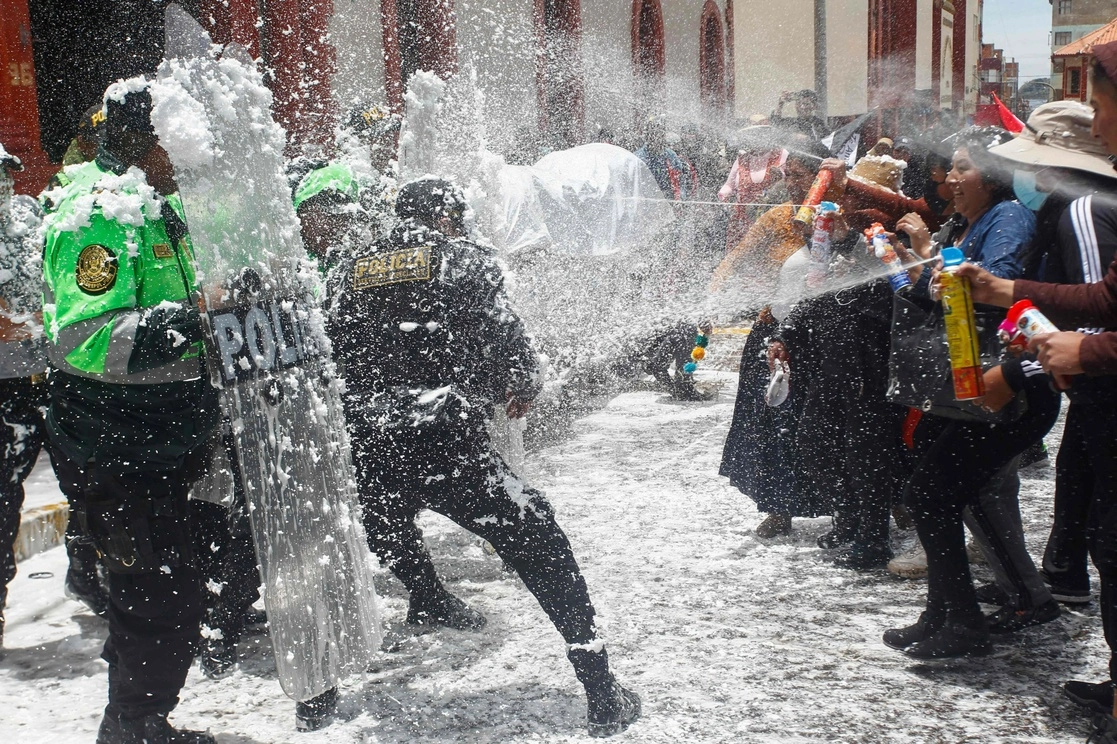 Tras la marcha los manifestantes empezaron a rociar espuma, agua, confeti y talco a los policías, que vestían sus cascos y equipos antimotines. Foto Afp.