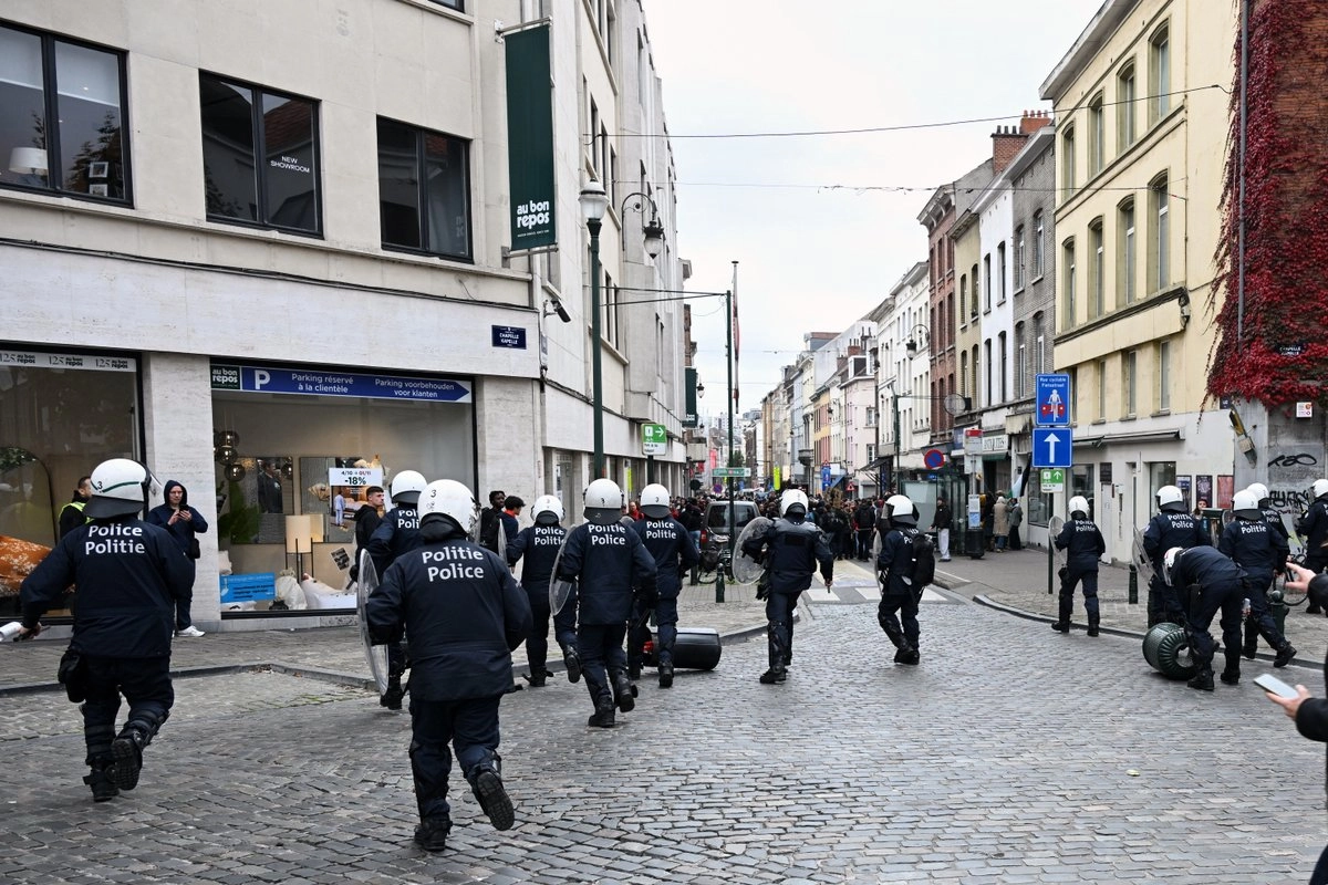 La policía persigue a los manifestantes por un callejón durante una manifestación y huelga general en Bruselas, el 14 de octubre de 2025.