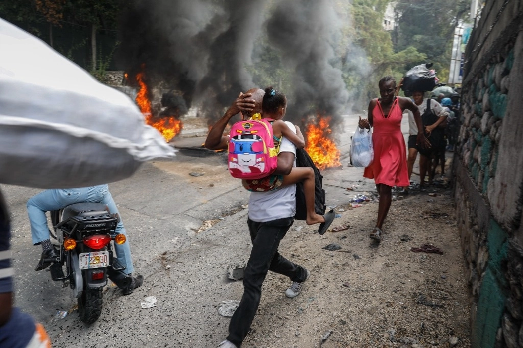 La gente pasa junto a neumáticos quemados durante una protesta contra el primer ministro haitiano, Ariel Henry, en Puerto Príncipe, Haití, 5 febrero 2024. Foto Ap.
