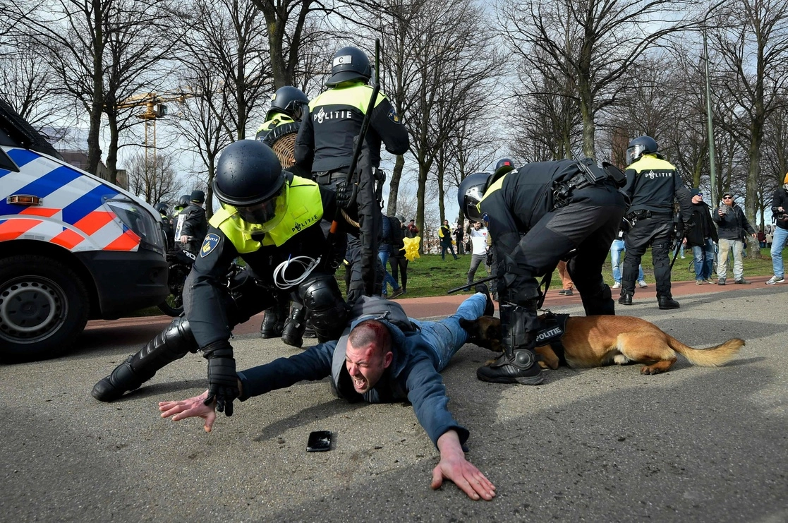Policía holandesa usa un elemento canino para detener a un manifestante en La Haya. Foto Afp