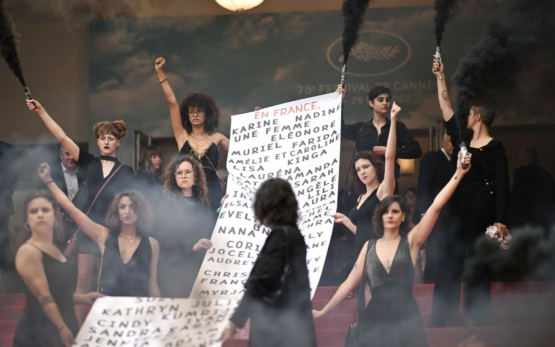 Feministas enarbolaron en la alfombra roja una pancarta con los nombres de 129 mujeres asesinadas en Francia desde el último festival de Cannes. Foto Afp