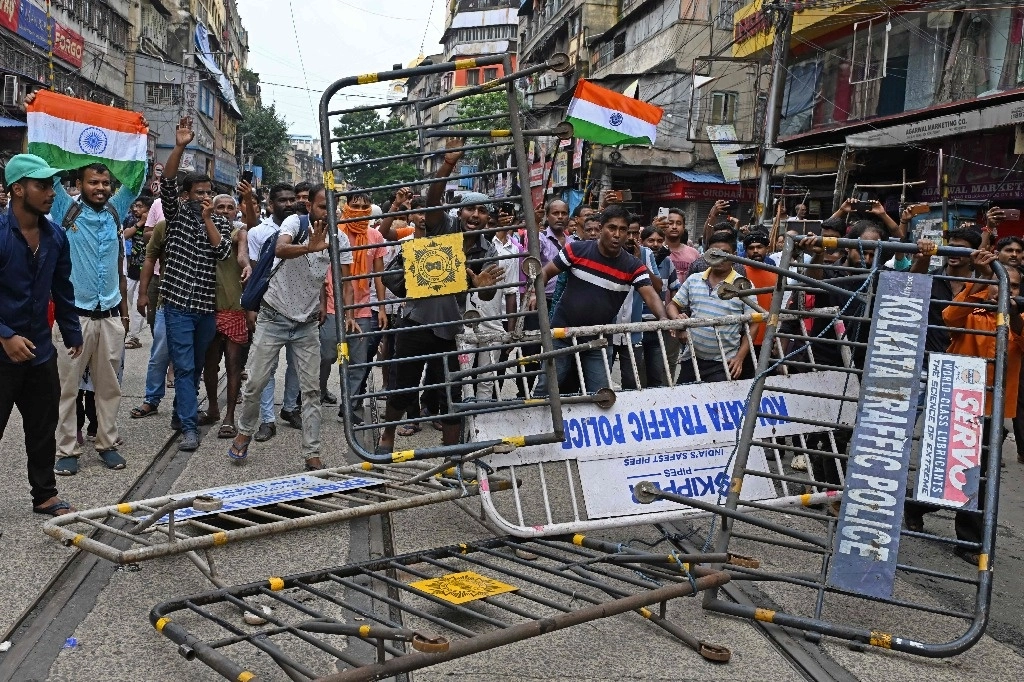Activistas destrozan barricadas policiales mientras marchan hacia la secretaría de estado exigiendo la dimisión de Mamata Banerjee, ministra principal del estado de Bengala Occidental de la India, en Calcuta, el 27 de agosto de 2024. Foto Afp