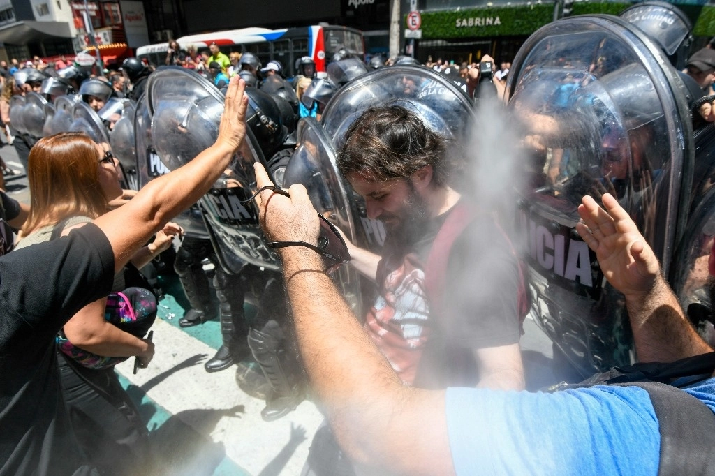 Un policía usa gas pimienta con manifestantes contra las reformas económicas del presidente argentino Javier Milei, afuera del Poder Judicial, en Buenos Aires, el 27 de diciembre de 2023. Foto Ap