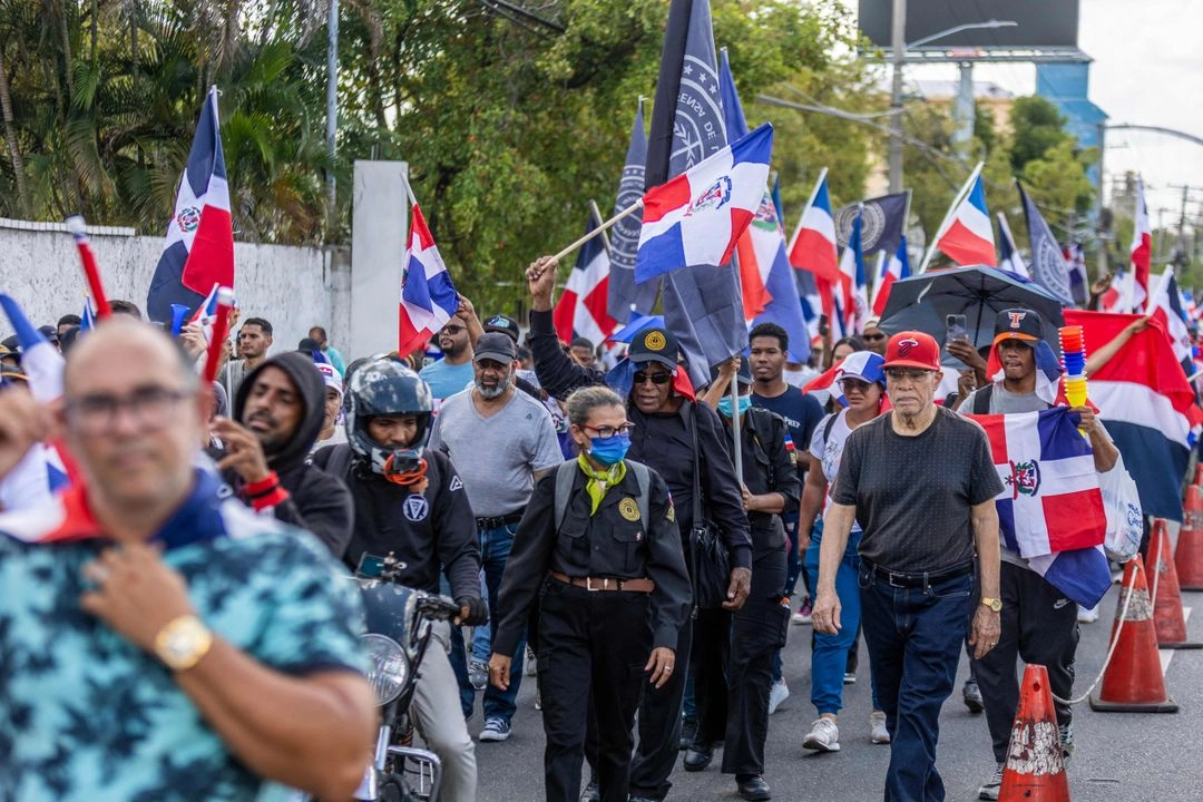 Simpatizantes del grupo nacionalista 'Antigua Orden Dominicana' ondean banderas de la República Dominicana mientras participan en una marcha contra la inmigración haitiana en Santo Domingo el 27 de abril de 2025.