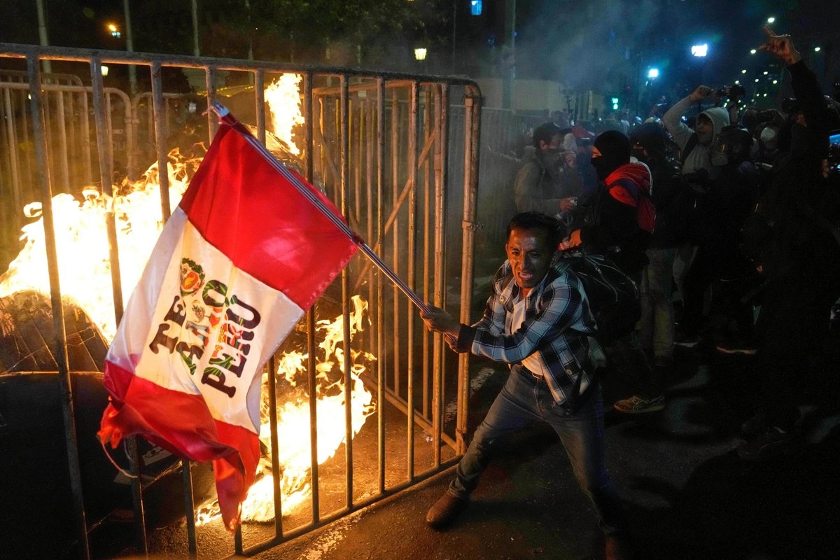 Manifestante onda una bandera de Perú durante una protesta frente al Congreso, en la que se exige la dimisión del nuevo presidente de la nación andina, José Jeri, el 15 de octubre de 2025. Foto 