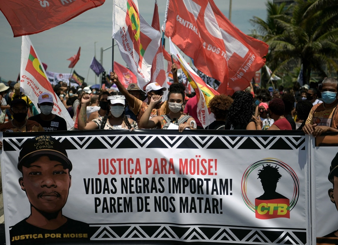 La gente protesta contra el asesinato del refugiado congoleño Moise Kabagambe, de 24 años, con una pancarta que dice “Justicia para Moise. Las vidas de los negros importan ¡Dejen de matarnos!” en el lugar de su muerte en Río de Janeiro, Brasil. Foto Afp
