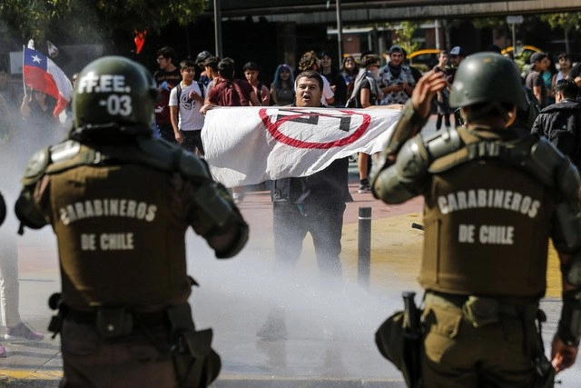 Un tenso encontrón protagonizaron dos grupos de manifestantes en Santiago. Algunos con una fotografía de Pinochet en brazos gritaron contra una nueva Constitución, en sentido opuesto a los que pedían su aprobación. Foto Afp