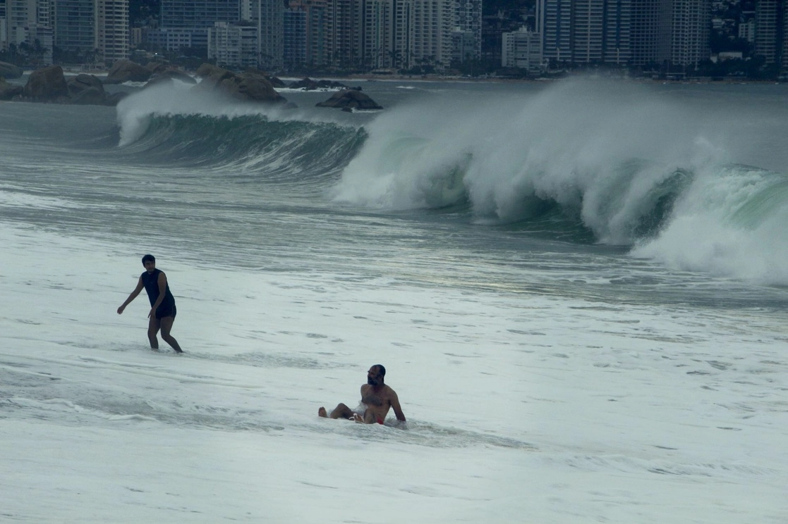 Dos personas disfrutan de las playas de Acapulco a pesar de la entrada del huracán 'Rick', el 24 de octubre de 2021. Foto Cuartoscuro